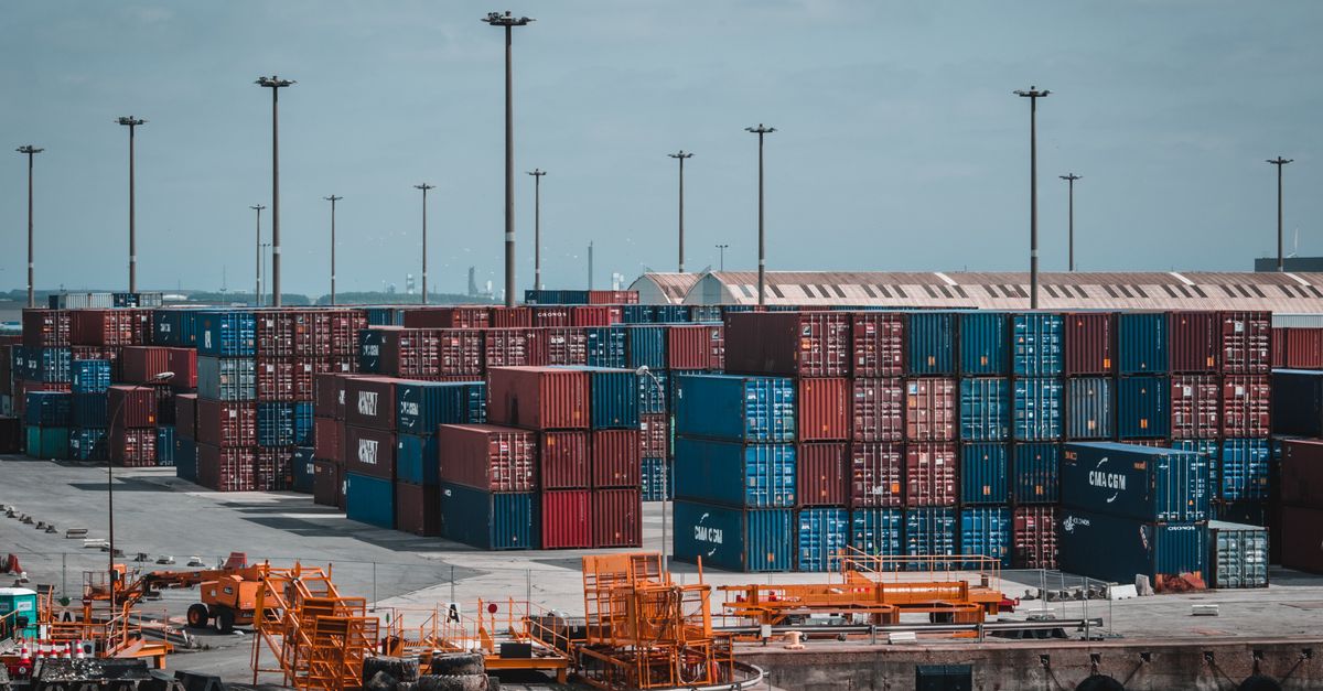 Colorful cargo containers stacked at a busy industrial port, showcasing global trade.